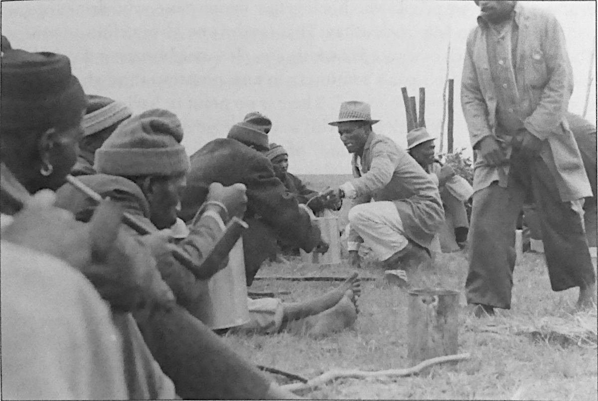 Partage de la bière entre travailleurs Xhosa. Inviter les autres à boire pendant un travail collectif. 1980